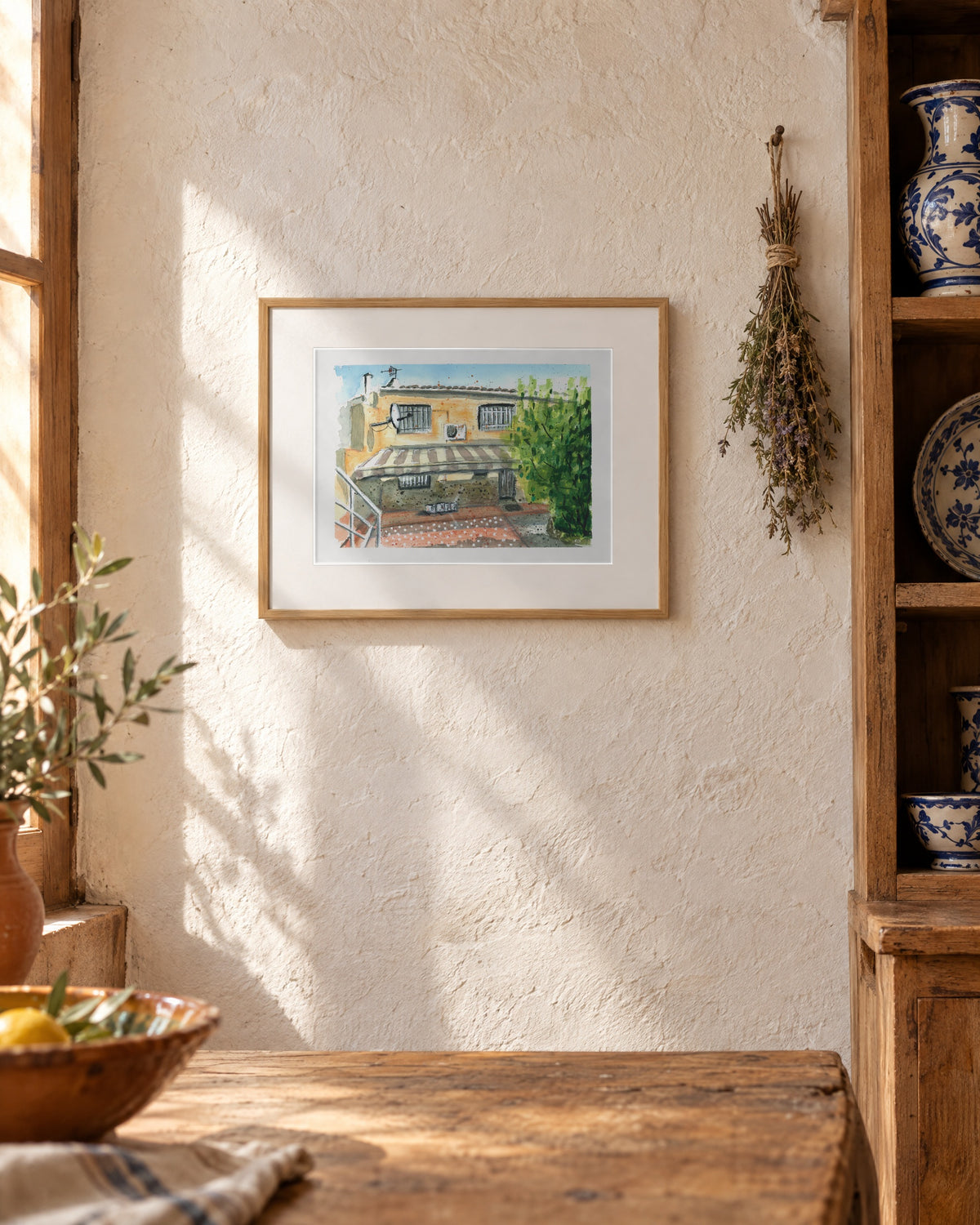 El patio de mi casa, acuarela original enmarcada en roble en una cocina con cerámica azul y blanca